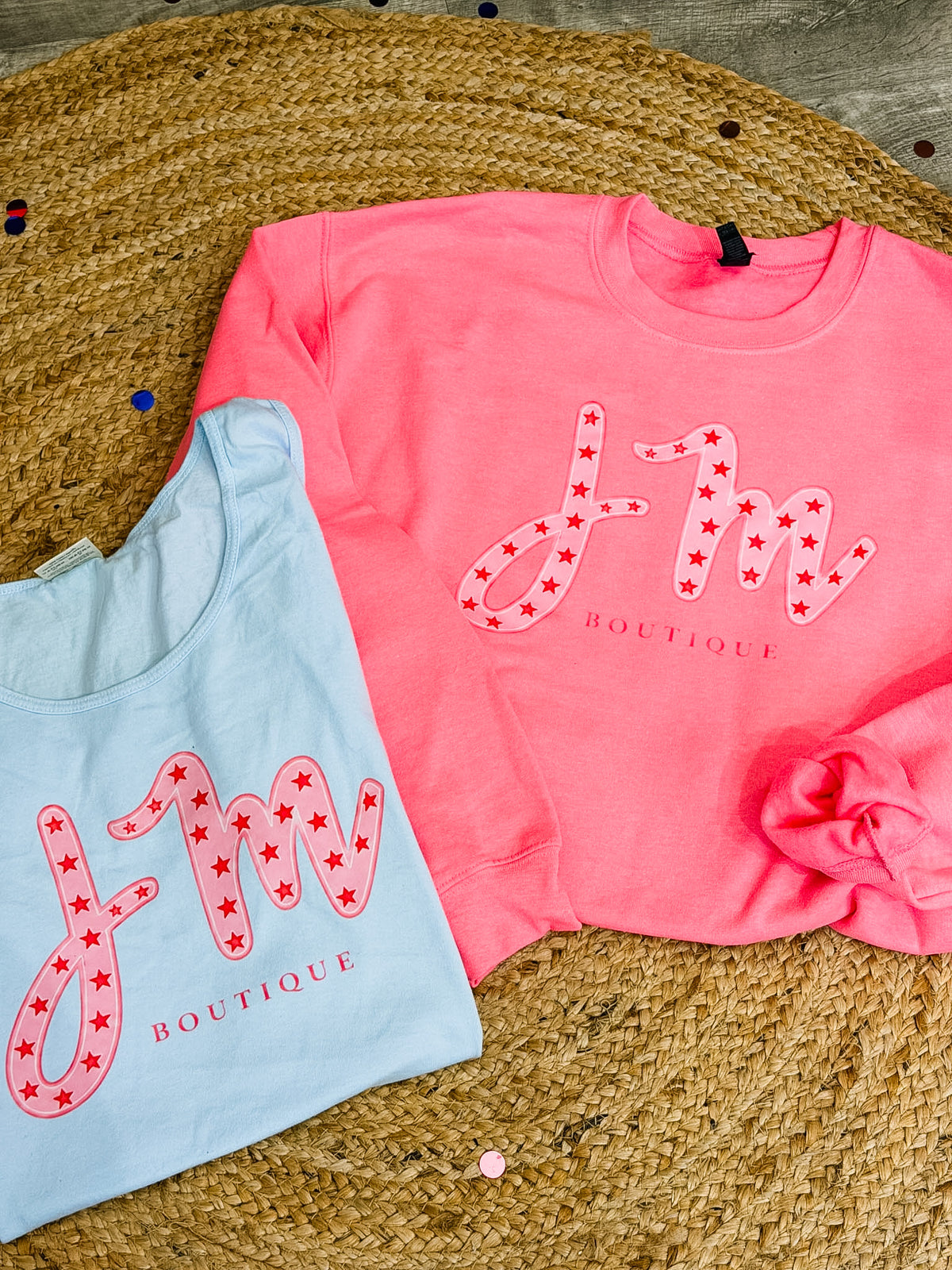 Pink and light blue JM birthday sweatshirts displayed together